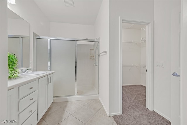 bathroom with tile patterned floors, vanity, and a shower with shower door