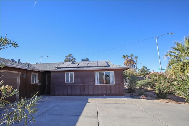 back of property featuring solar panels