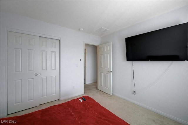 unfurnished bedroom with light carpet and a closet