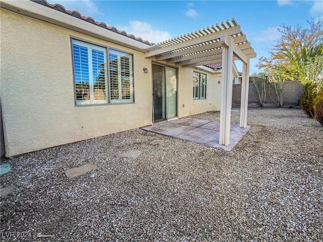 rear view of property featuring a patio and a pergola