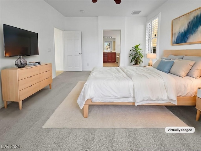 carpeted bedroom with ensuite bathroom and ceiling fan