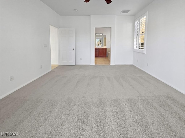 spare room with ceiling fan and light carpet