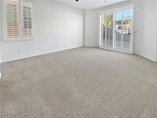 carpeted spare room with ceiling fan