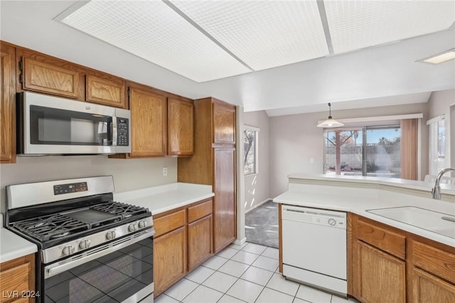 kitchen featuring decorative light fixtures, stainless steel appliances, light tile patterned floors, and sink