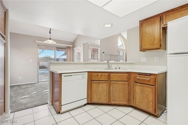 kitchen with light carpet, kitchen peninsula, white appliances, sink, and lofted ceiling