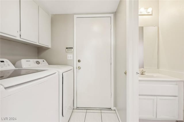 washroom featuring light tile patterned flooring, separate washer and dryer, cabinets, and sink