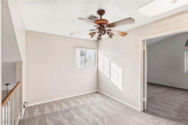 carpeted empty room with ceiling fan and a textured ceiling