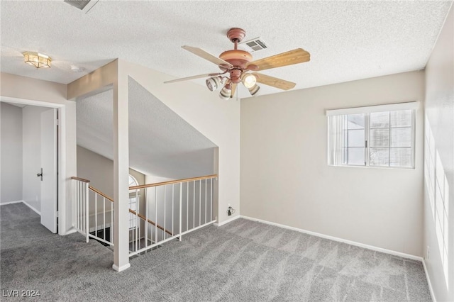 interior space featuring ceiling fan, carpet floors, and a textured ceiling