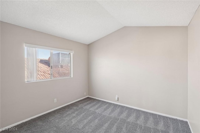 spare room with carpet, a textured ceiling, and lofted ceiling