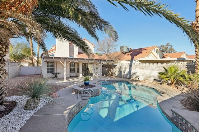 view of pool featuring a patio area, central air condition unit, and an in ground hot tub