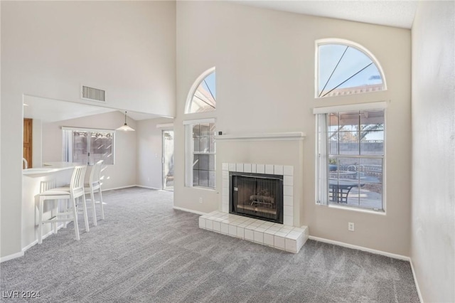 unfurnished living room with a wealth of natural light, carpet floors, and a high ceiling