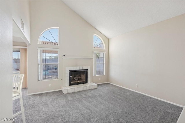 unfurnished living room with carpet flooring, plenty of natural light, a fireplace, and high vaulted ceiling