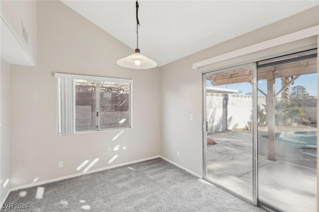 carpeted empty room featuring vaulted ceiling