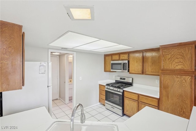 kitchen with sink, light tile patterned floors, and stainless steel appliances