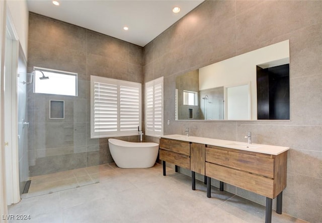 bathroom featuring tile patterned flooring, vanity, independent shower and bath, and tile walls