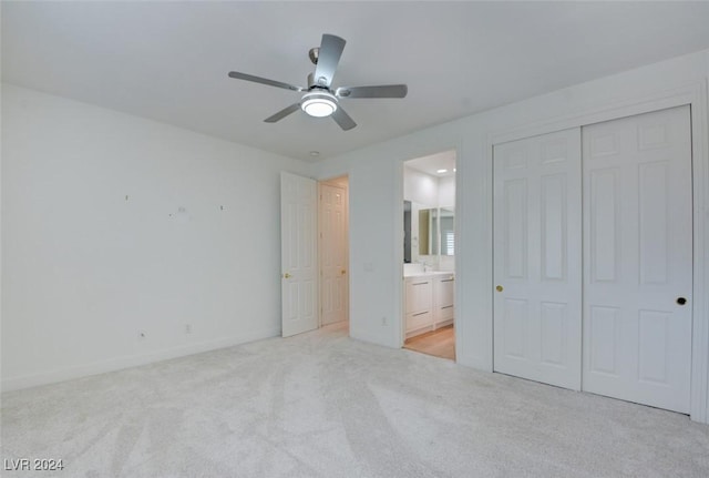 unfurnished bedroom with ceiling fan, light colored carpet, and connected bathroom