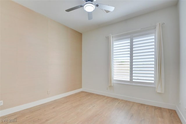 empty room with ceiling fan and light hardwood / wood-style floors