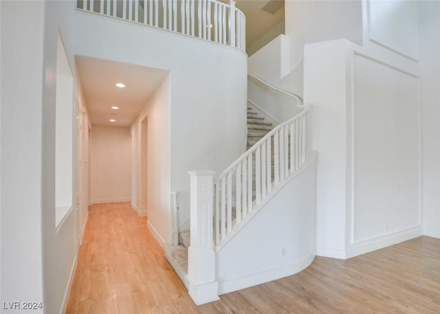 staircase featuring hardwood / wood-style floors and a towering ceiling