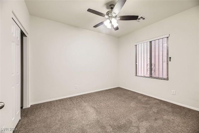 unfurnished bedroom with ceiling fan, a closet, and dark carpet