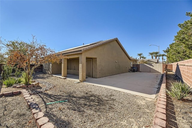 back of house with central AC unit and a patio