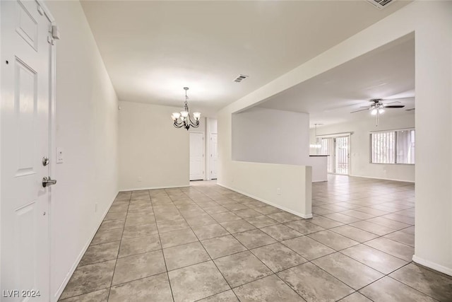 empty room featuring ceiling fan with notable chandelier and light tile patterned floors