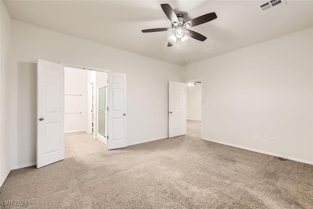 unfurnished bedroom with ceiling fan and light colored carpet