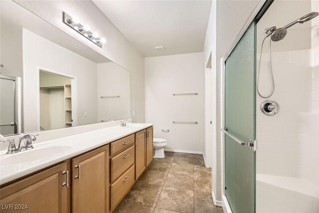 bathroom with tile patterned floors, vanity, toilet, and an enclosed shower