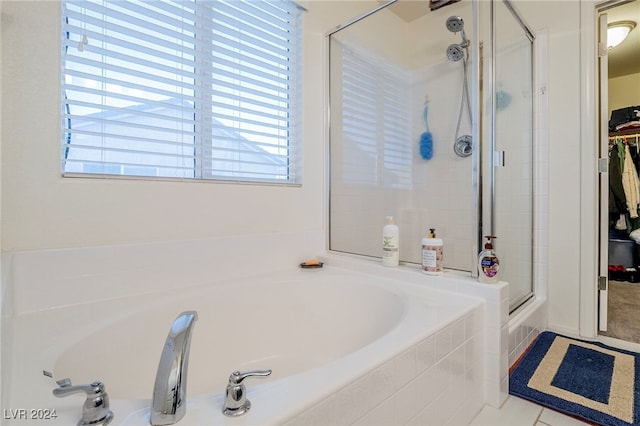 bathroom featuring plus walk in shower, tile patterned floors, and a healthy amount of sunlight