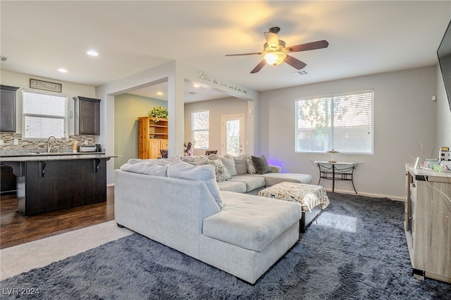 living room with ceiling fan, dark wood-type flooring, and sink