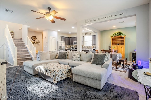 carpeted living room with ceiling fan