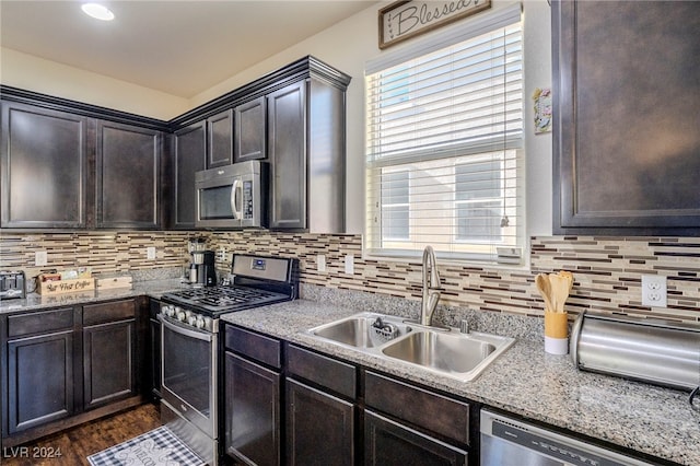 kitchen featuring dark brown cabinetry, sink, appliances with stainless steel finishes, and tasteful backsplash