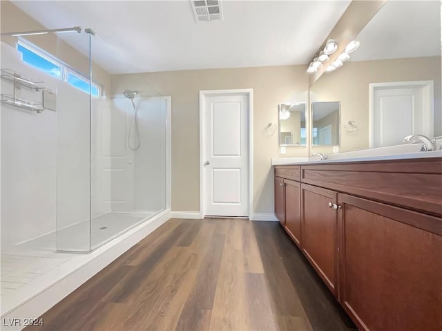 bathroom featuring hardwood / wood-style floors, vanity, and walk in shower