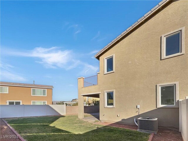 view of home's exterior featuring central AC, a yard, and a balcony