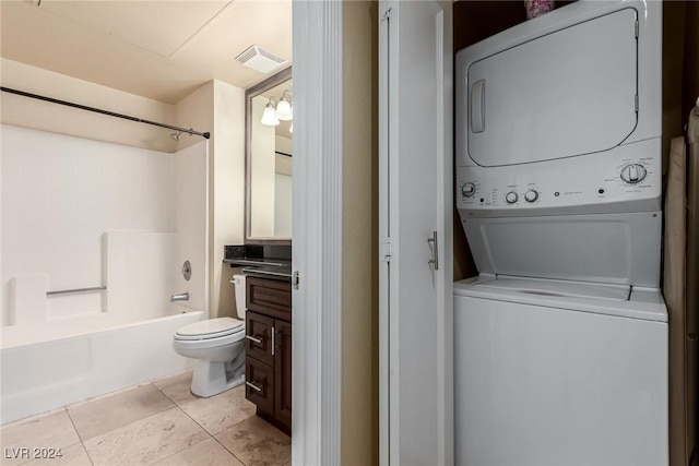 laundry room featuring light tile patterned floors and stacked washer and dryer