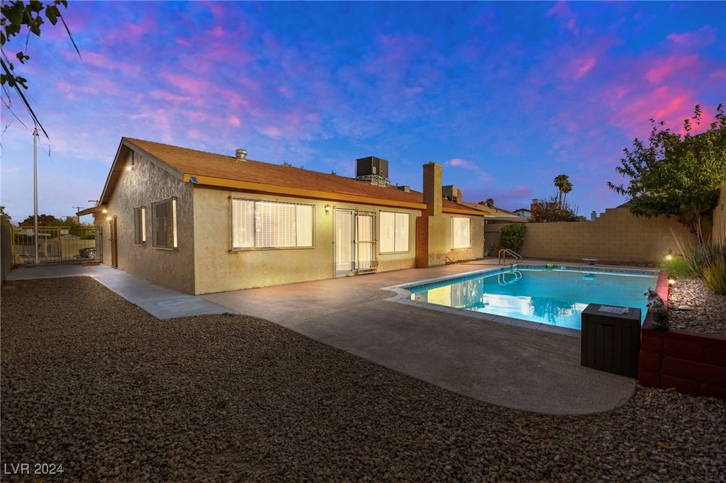 pool at dusk with a patio