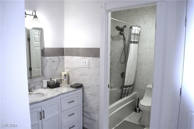 full bathroom with vanity, toilet, tile walls, and shower / bath combo with shower curtain