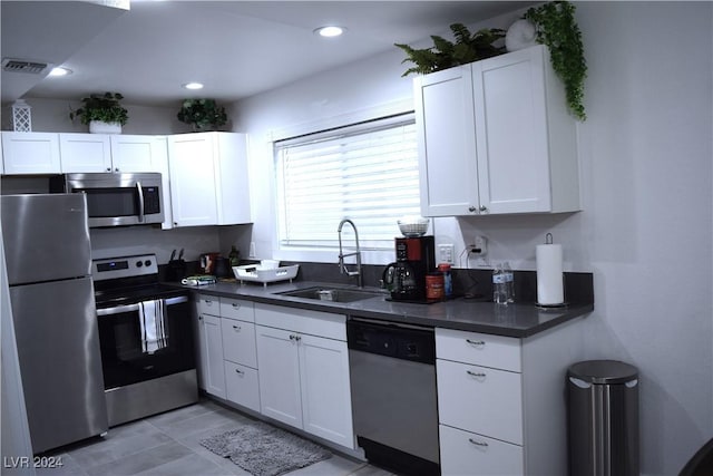 kitchen with stainless steel appliances, white cabinetry, and sink