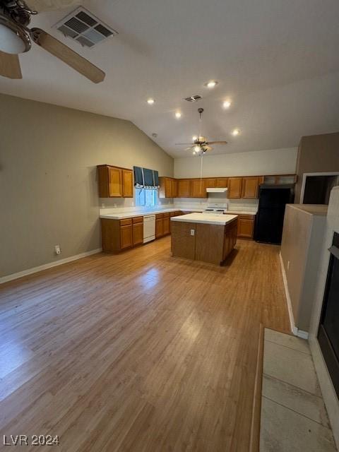 kitchen featuring a center island, lofted ceiling, white appliances, ceiling fan, and light hardwood / wood-style floors