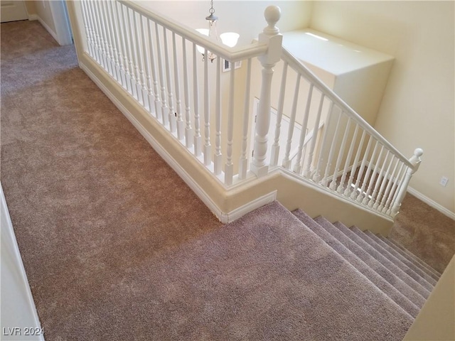 stairway featuring carpet flooring and a notable chandelier