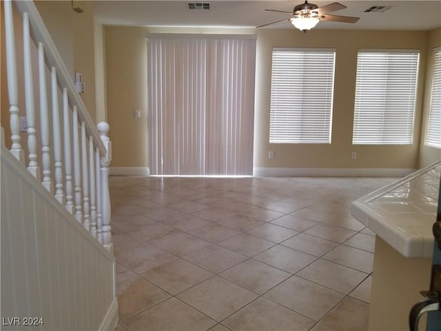 unfurnished living room with light tile patterned floors and ceiling fan