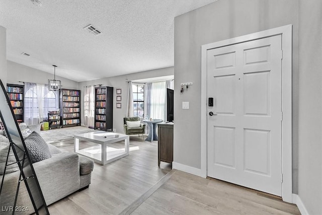 entrance foyer featuring light hardwood / wood-style flooring, a wealth of natural light, and lofted ceiling