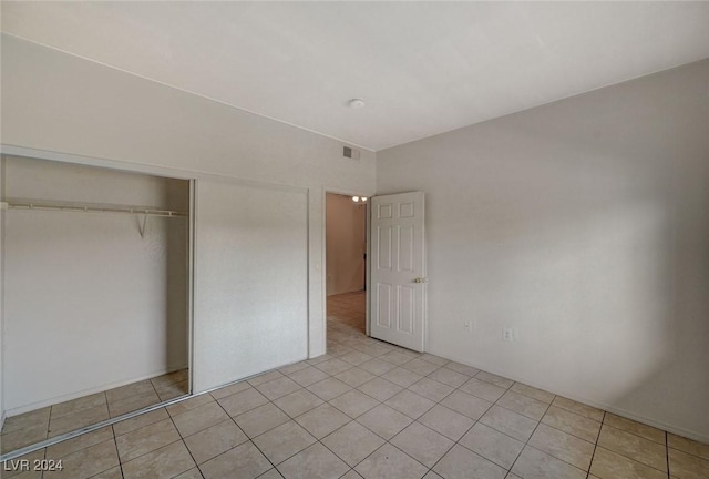 unfurnished bedroom featuring a closet and light tile patterned floors