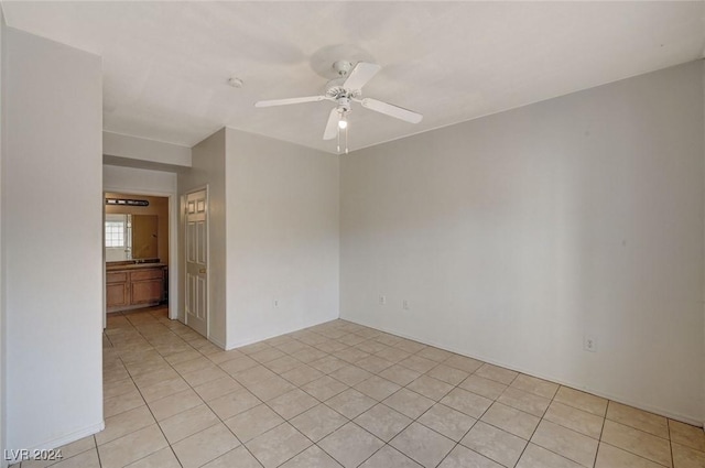 tiled spare room with ceiling fan