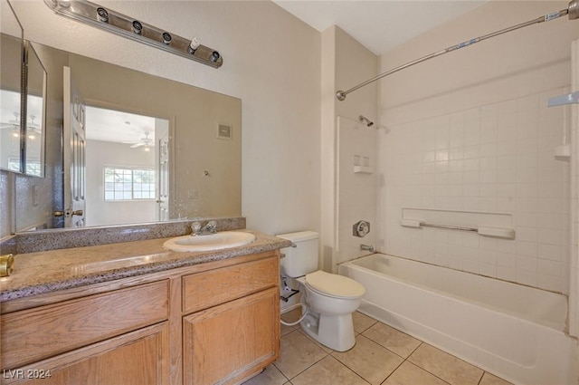 full bathroom featuring vanity, ceiling fan, tile patterned flooring, toilet, and tiled shower / bath