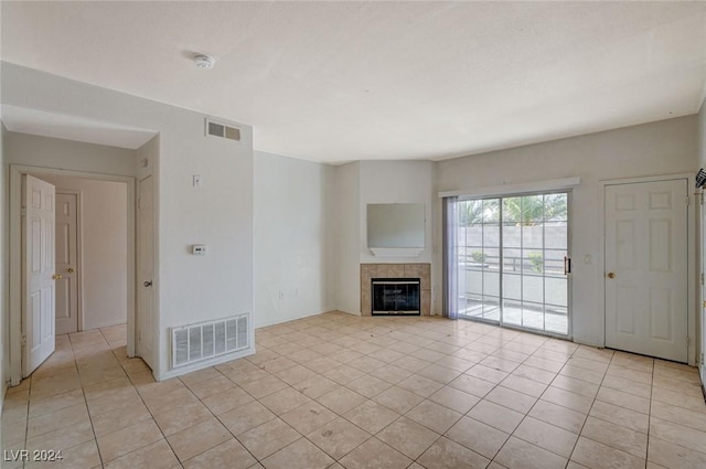 unfurnished living room featuring a fireplace and light tile patterned floors