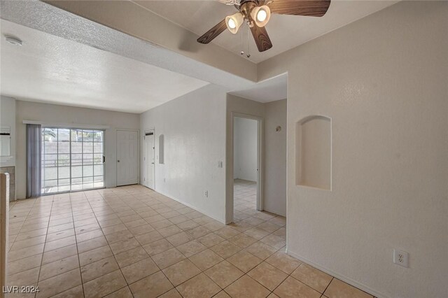 spare room featuring light tile patterned floors and ceiling fan