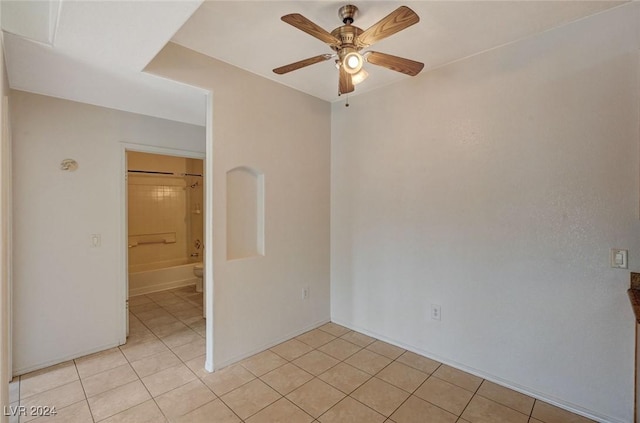 tiled spare room featuring ceiling fan