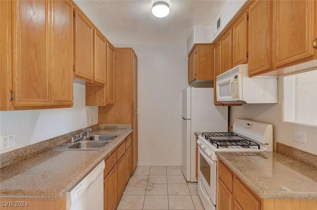 kitchen featuring a textured ceiling, light stone countertops, white appliances, and sink