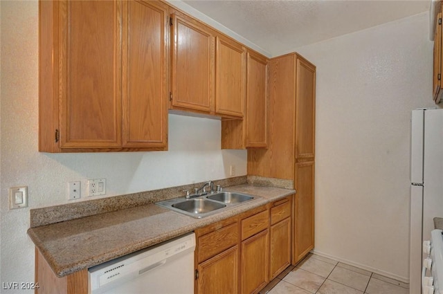 kitchen with light tile patterned flooring, white appliances, and sink