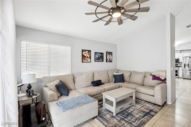 living room with ceiling fan, light tile patterned floors, and lofted ceiling